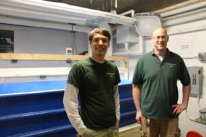 The Maryland Zoo's Kyle Baumgartner & Kevin Barrett (L-R) near the juvenile hellbender holding tank